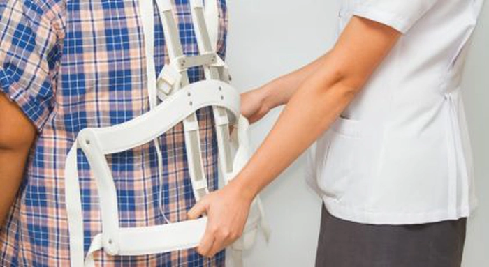 un bărbat care probează un corset pentru spondiloza cervicală