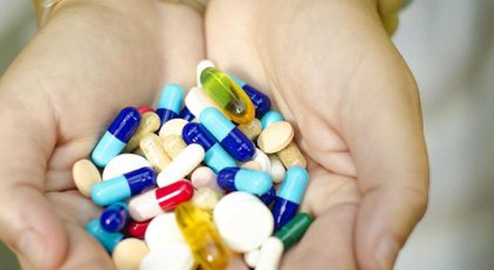 mai multe medicamente colorate în mâinile unei persoane