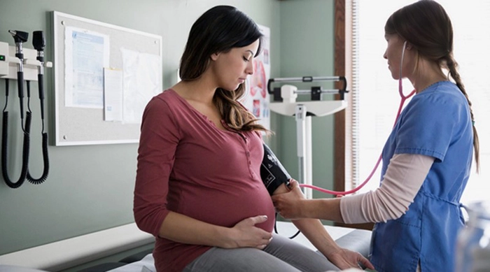 medic care verifica tensiunea unei femei insarcinate