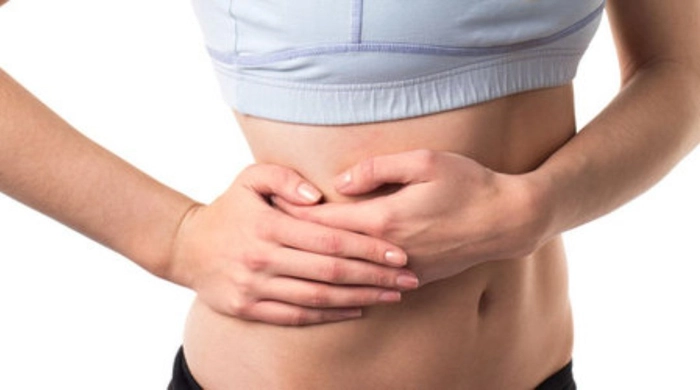 femeie care se tine de partea dreapta a abdomenului din cauza durerii