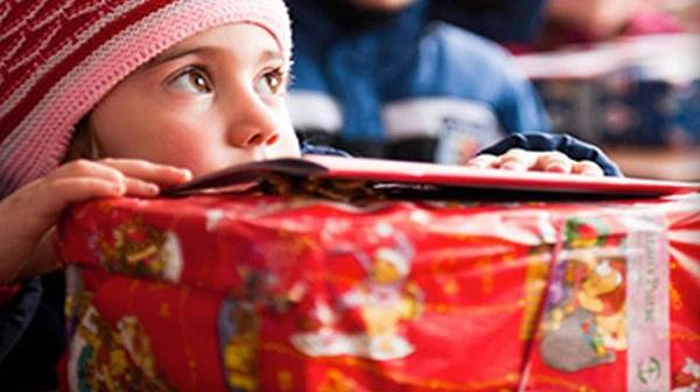 copil cu un cadou rosu in fata