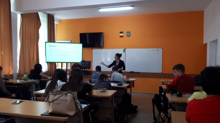 o sala de clasa si elevi care se uita la un ecran
