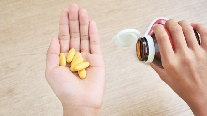 medicamente galbene în palma unei persoane