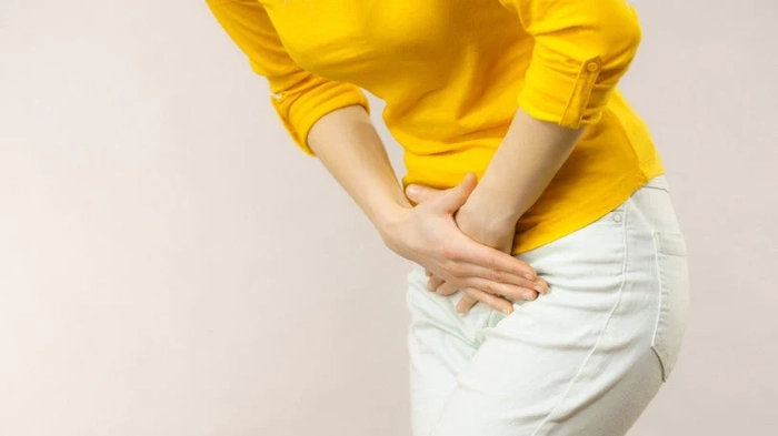 femeie care se tine de zona intima din cauza vezicii urinare inflamate