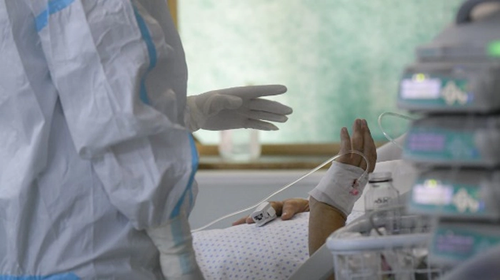 Mana unui cadru medical apropiindu-se de mana unui pacient