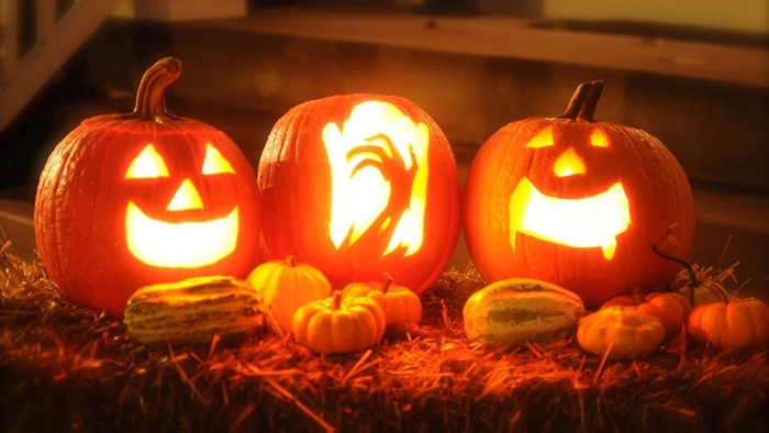 trei dovleci mari cu fete infricosatoare de Haloween pe o scara
