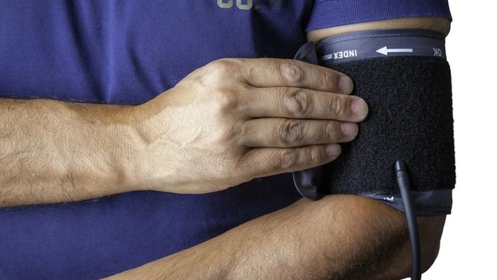 persoana care isi masoara tensiunea cu un tensiometru