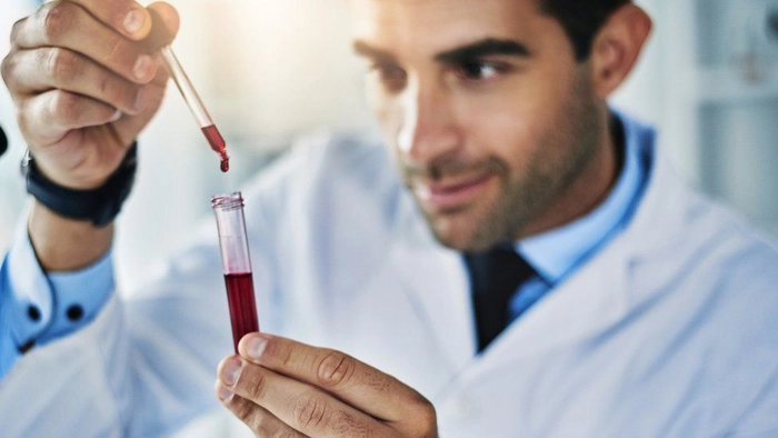pipeta cu doctor ce tine o eprubeta cu sange