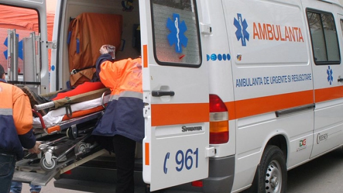 Doua persoane urca o targa cu un pacient intr-o masina a Serviciului de Ambulanta