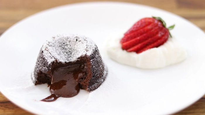 lava cake langa inghetata si capsuna pe farfurie