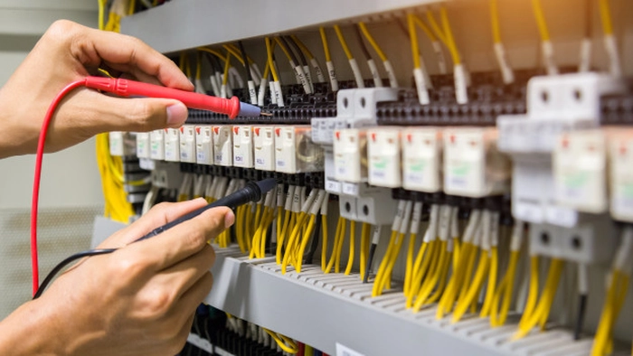 un electrician care lucreaza la un panou electric