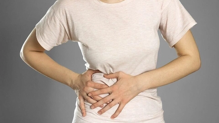femeie care se tine de pancreas din cauza colesterolului