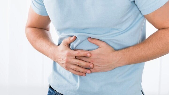 barbat care se tine de abdomen din cauza durerii provocate de pancreas