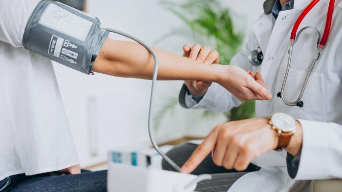 medic care verifica cu un pulsiometru tensiunea unei persoane