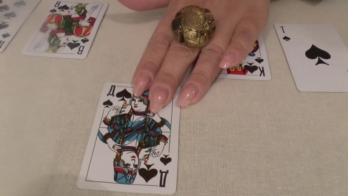 femeie care tine mana pe o carte de joc 