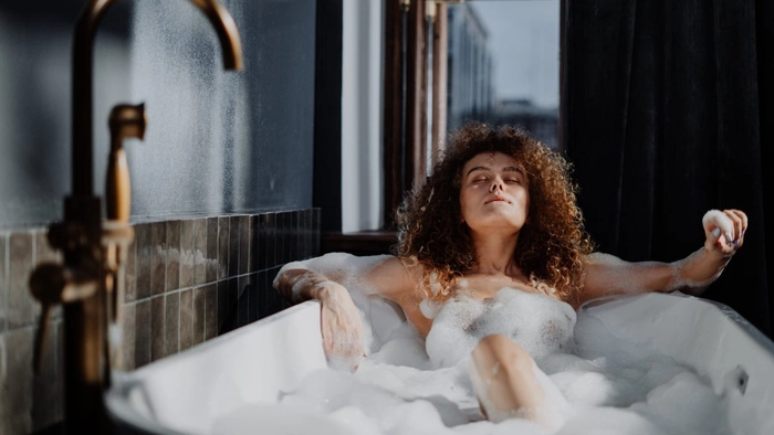 o femeie creață care se relaxează în cadă