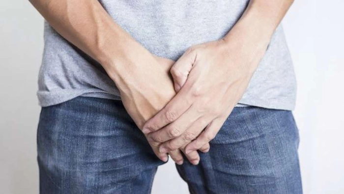 un bărbat care își acoperă cu mânile zona intimă