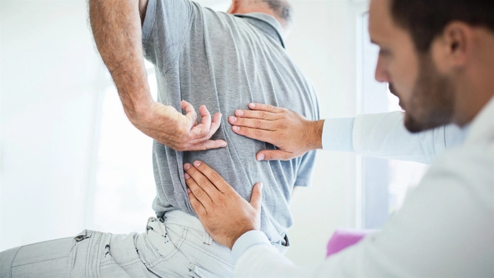 medic care examineaza spatele unui barbat