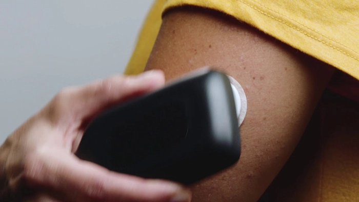 femeie care isi verifica nivelul de glucoza din sange folosind un glucometru neinvaziv