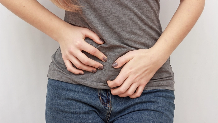 femeie care se tine de zona intima din cauza vezicii urinare inflamate