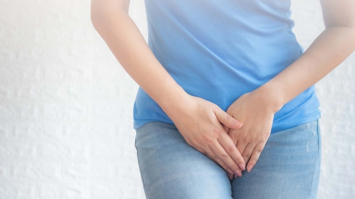 femeie care se tine de zona intima din cauza infectiei genitale