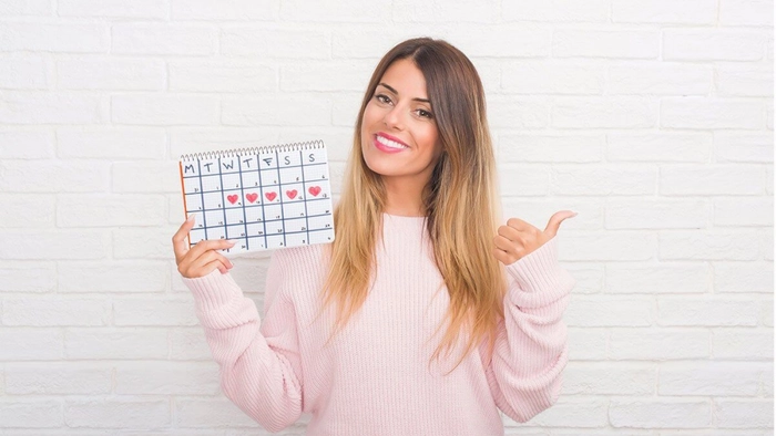 femeie care tine un calendar in mana si tine un deget in sus