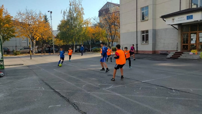 copii pe terenul de sport ce joaca fotbal