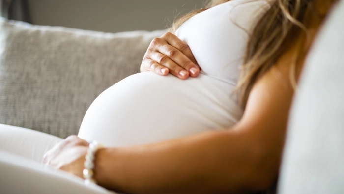 femeie insarcinata care sta culcata si se tine de burta