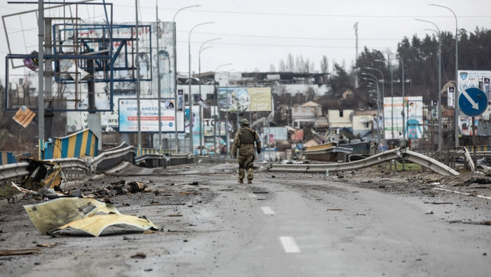 acuzaţiile de genocid de lângă Kiev, soldat al armatei ucrainene ce se plimba pe o strada plina de urme ale invaziei ruse