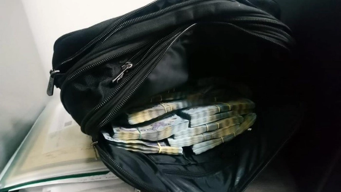  o geanta cu mai multe teancuri de bani