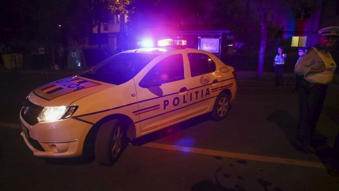  o masina de politie si un politist langa