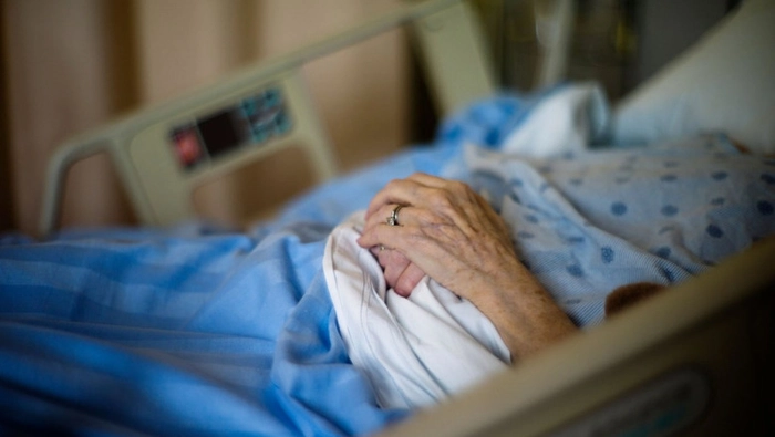 o batrana pe un pat de spital