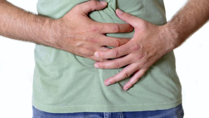 persoana care se tine cu mainile de abdomen