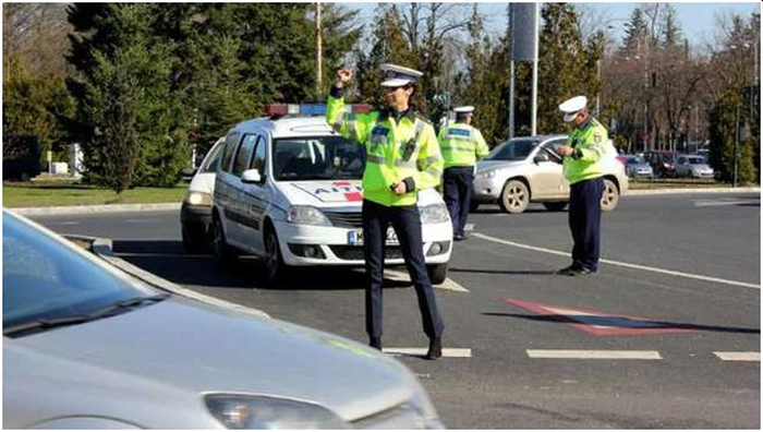 trei politisti dirijand circulatia din oras