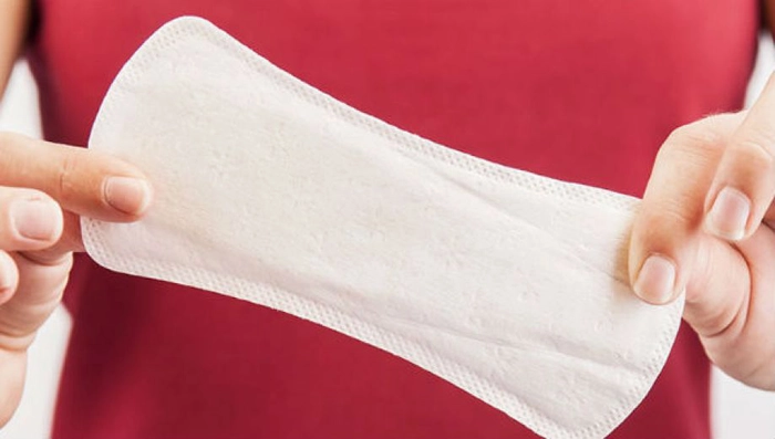 persoana care tine un absorbant in mana