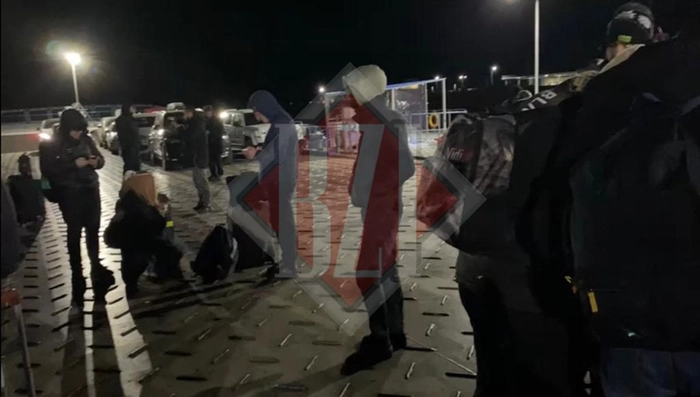 mai multe persoane stau si asteapta la frontiera pe timp de noapte