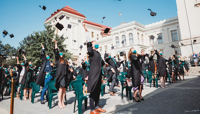 studenti care isi arunca toca in ziua absolvirii