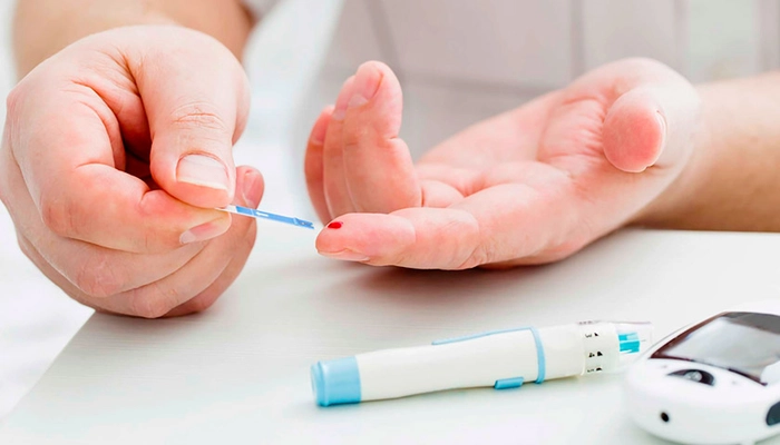 persoana care efectueaza un test de sange pentru a identifica nivelul de glicemie