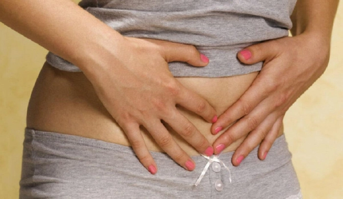 femeie care se tine de josul abdomenului din cauza fibromului uterin