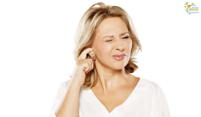 femeie care tine un deget in ureche din cauza mancarimii de care sufera