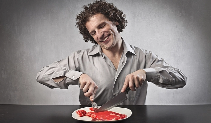 barbat care mananca dintr-o farfurie o bucata de carne 