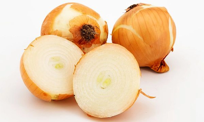 ceapa intrega si taiata pe o masa
