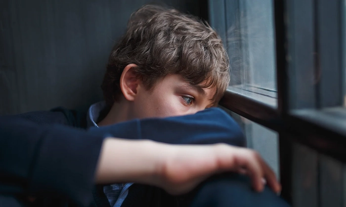 adolescent ce sta trist langa geam