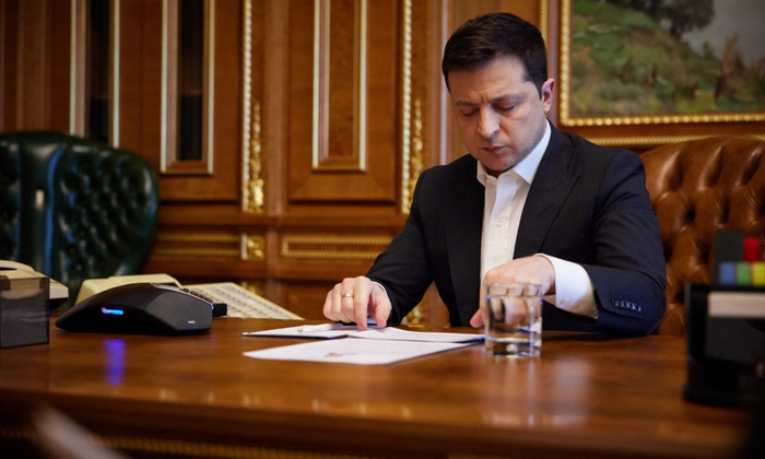 presedintele Ucrainei, Volodimir Zelenski, la birou, studiind niste documente, Zelenski cere ajutorul Germaniei