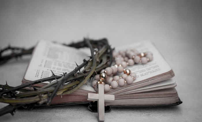 coroana de spini si o cruce pe o biblie
