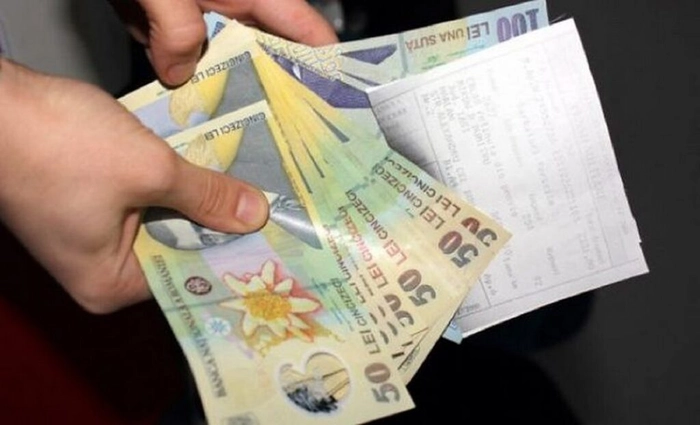 o persoana care tine bani si o foaie in mana