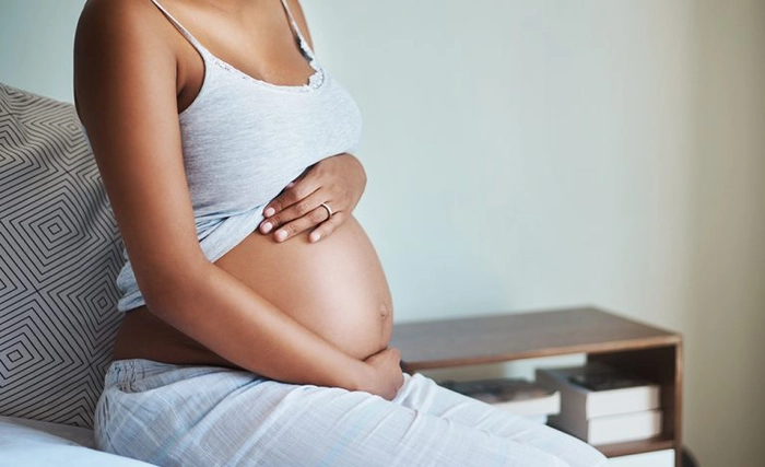 femeie insarcinata care se tine de burta