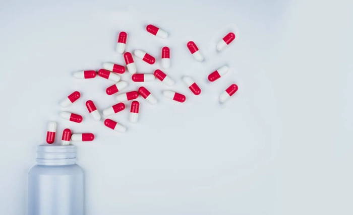 un recipient din care au cazut mai multe antibiotice pe o masa
