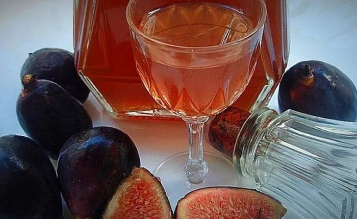 un pahar de vin langa smochine pe o masa