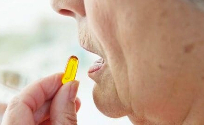 femeie care administreaza o capsula de omega 